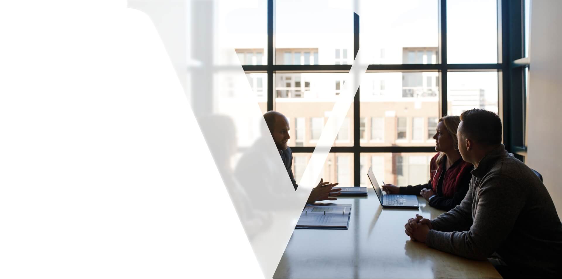 Homepage Hero Vogel law logo overlay on picture of 4 people having a discussion at a table inside the vogel law office