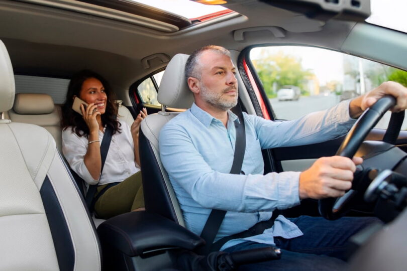 Driver and passenger riding together in a car with seat belts on