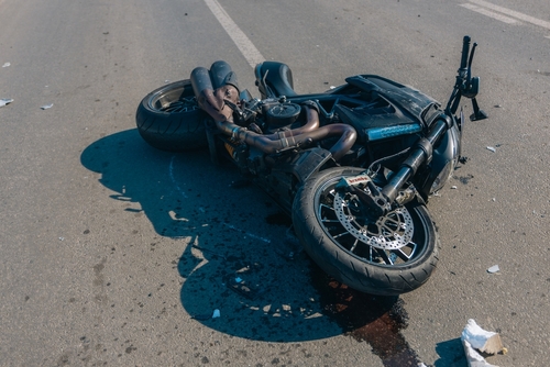 Black,motorcycle,with,serious,damage,is,on,the,asphalt.,accident