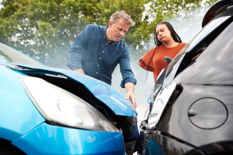 Man and woman analyzing car damages after a rear end car crash